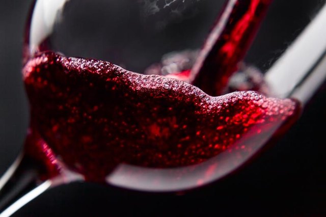 Red wine in wineglass on black background