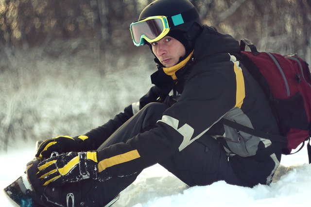 Man gets snowboard and looks at the camera