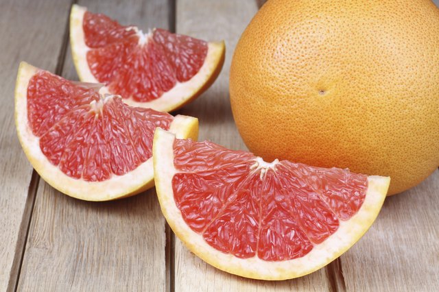 Sliced red grapefruit on a wooden background