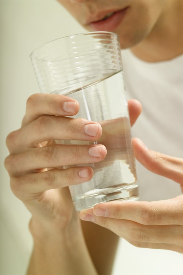 Young man holding glass of water, close-up
