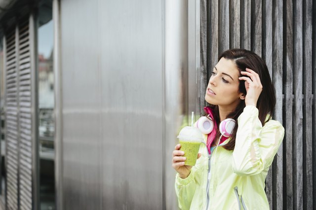 Fitness woman with detox smoothie cup