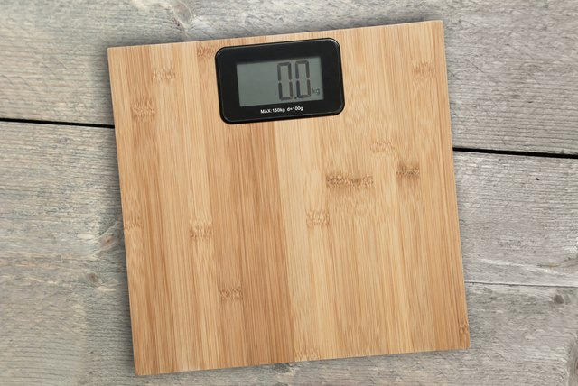 Electronic floor scale on a wooden background