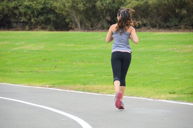 Athletic young woman running on track