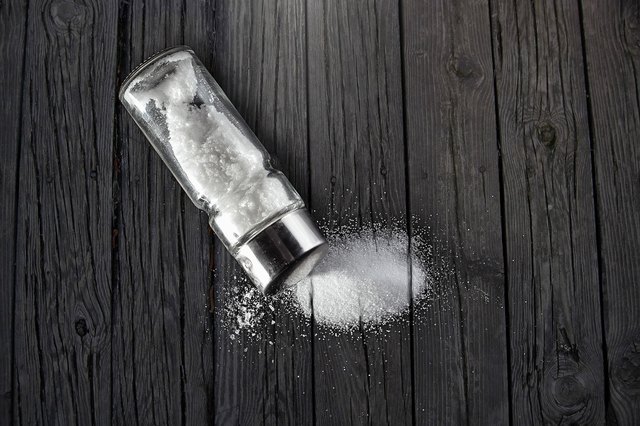 salt, sprinkled salt on a black wooden table