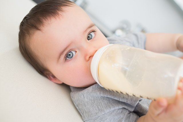 Baby drinking milk while lying on counter