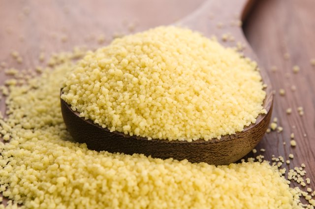 couscous in wooden spoon on kitchen table