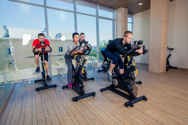 Group of gym people on machines, cycling In Class