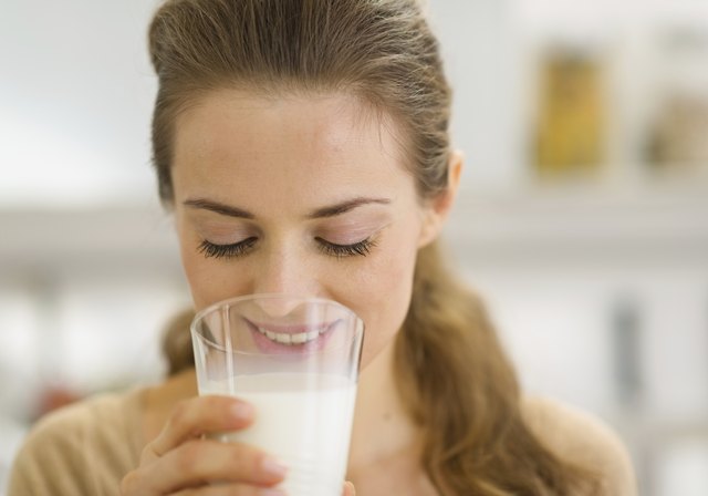 Young woman drinking milk in kitchen