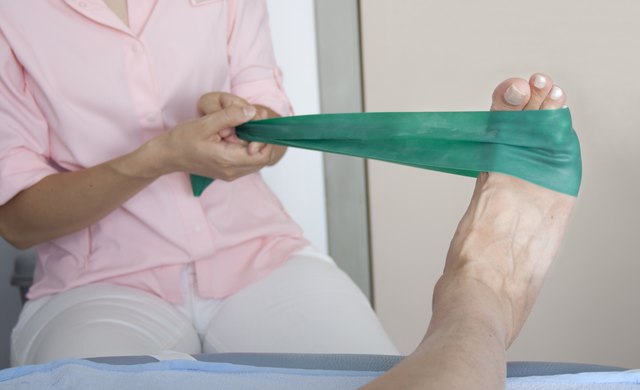 physical therapist helping a patient to exercise with resistance band