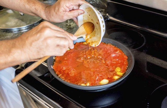 Emptying Ingredients into Frying Pan to make Italian Sauce