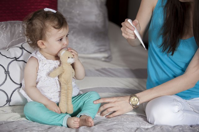 Young mom reading her baby's temperature