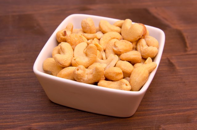Cashew nuts on bowl on wood