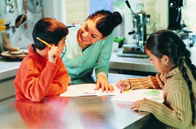 Mother Assisting Her Children With Homework in a Kitchen