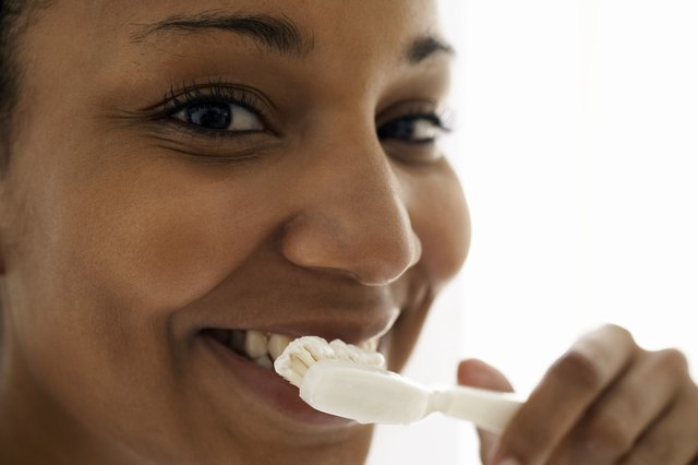 Young woman brushing teeth, close-up, portrait