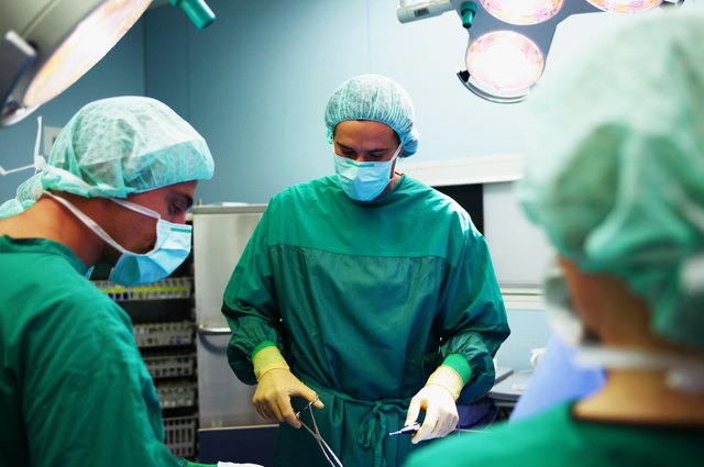 Operating theatre team tending to patient, surgeon operating