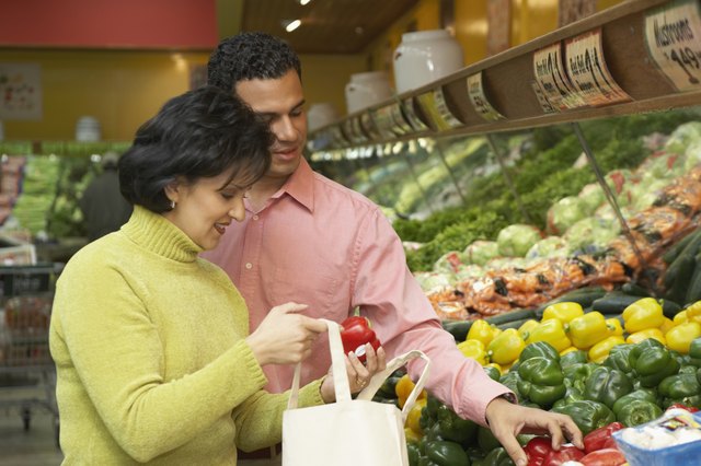 Mid adult woman holding red bell peppers
