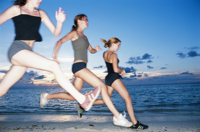 Young woman running at beach, low angle view