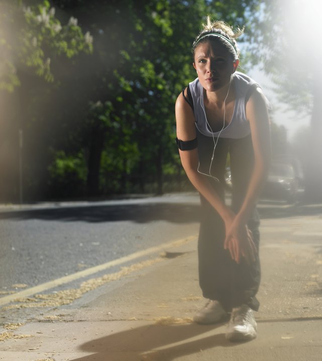 Young woman on street stretching before jogging