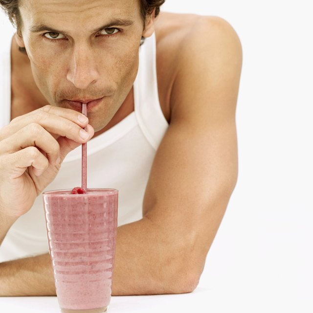 Portrait of a man drinking juice from a glass with a straw