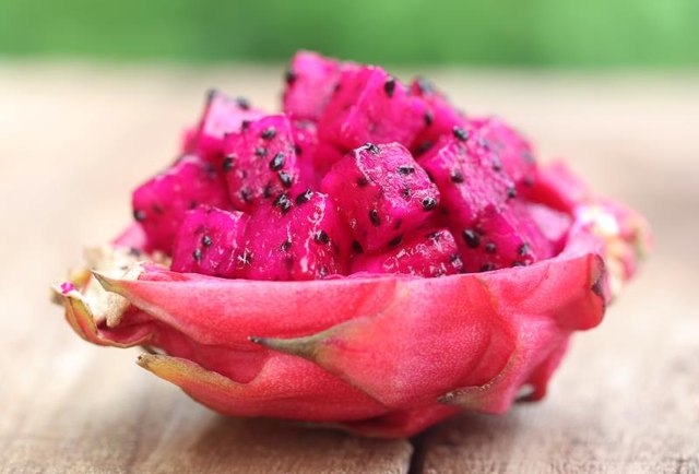 Pieces of dragon fruit on wooden surface