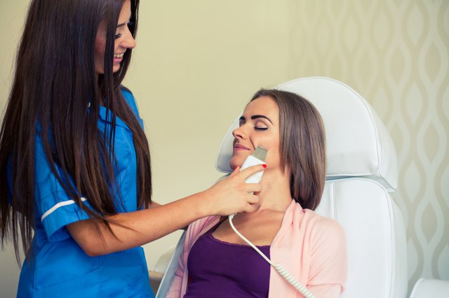 Picture of pretty beautician doing microdermabrasion procedure.