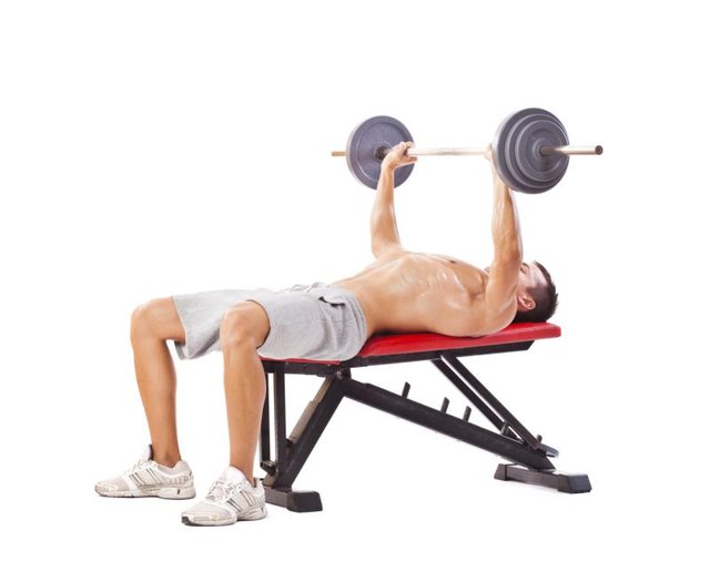 Handsome man doing bench press. Studio shot, isolated on white.