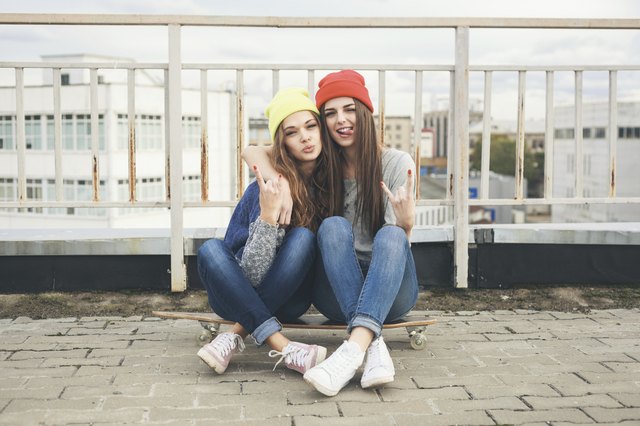 Two young longboarding girl friends