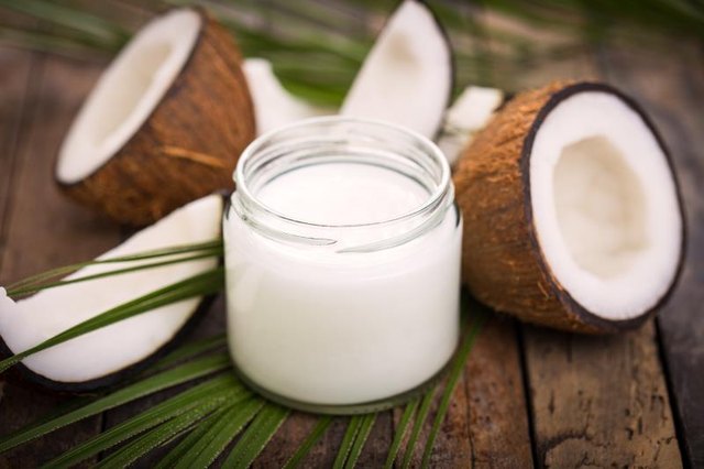 A jar of coconut oil on a wooden table