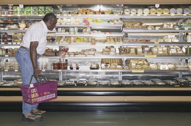 Elderly man shopping at a supermarket holding a shopping basket