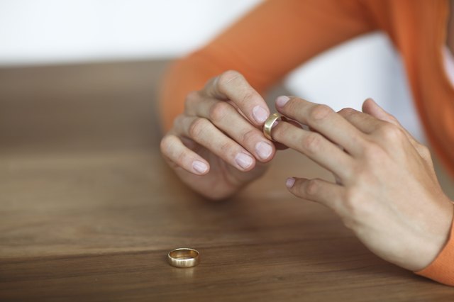 Mid adult woman toying with gold wedding ring on finger