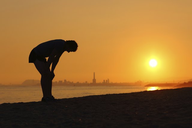 Silhouette of an tired sportsman at sunset