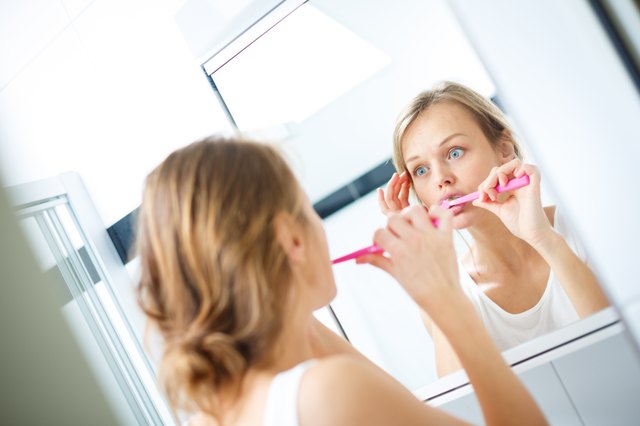 Pretty female brushing her teeth