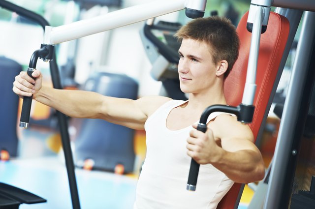 positive man at chest exercises machine