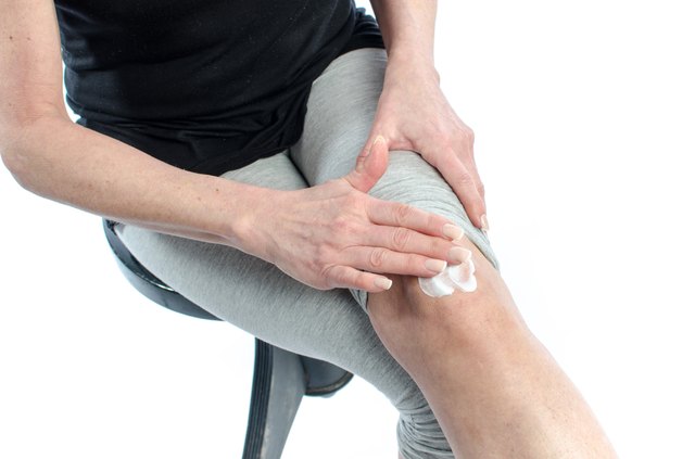 Woman putting cream on her knee