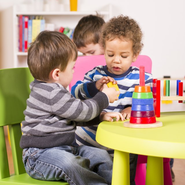 Toddlers helping and sharing in the playroom