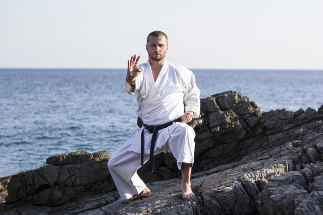 Master of martial arts exercise on the rock by the sea