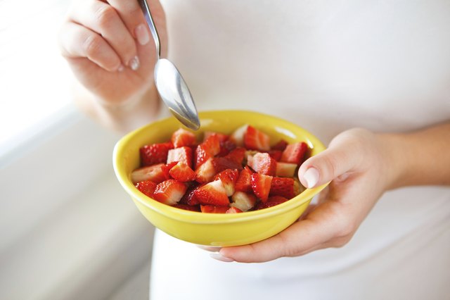 Woman holding fresh strawberries in a bowl