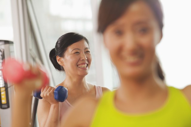 Mature women lifting weights in the gym