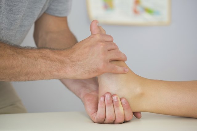 Physiotherapist controlling patients foot