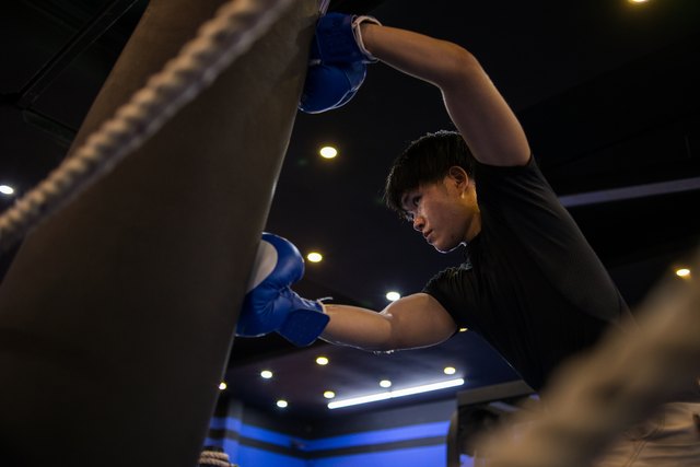 Man punching the boxing sandbag with his right hand