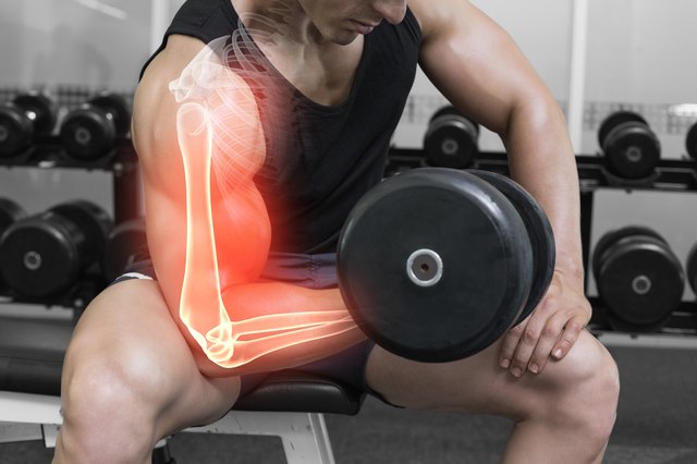 Highlighted arm of strong man lifting weights