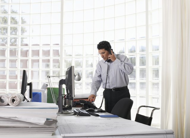Male architect using telephone at desk