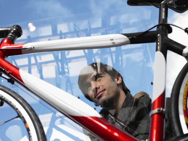 Man looking at bicycle, low angle view through glass