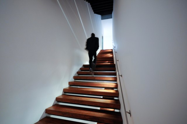 Silhouette figure waling up stairs.