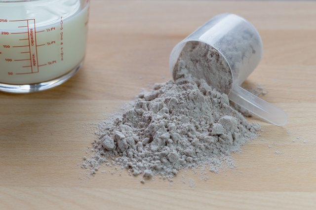 scoop of whey protein on wooden table