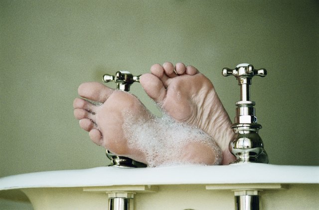 Woman in bath, low section, close-up of feet