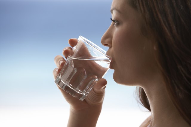 Young Woman Drinking Water by Sea