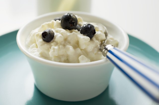 Cottage cheese with blueberries and spoon in a small bowl