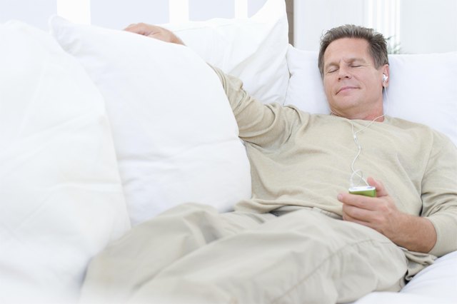Middle-aged man listening to music on sofa