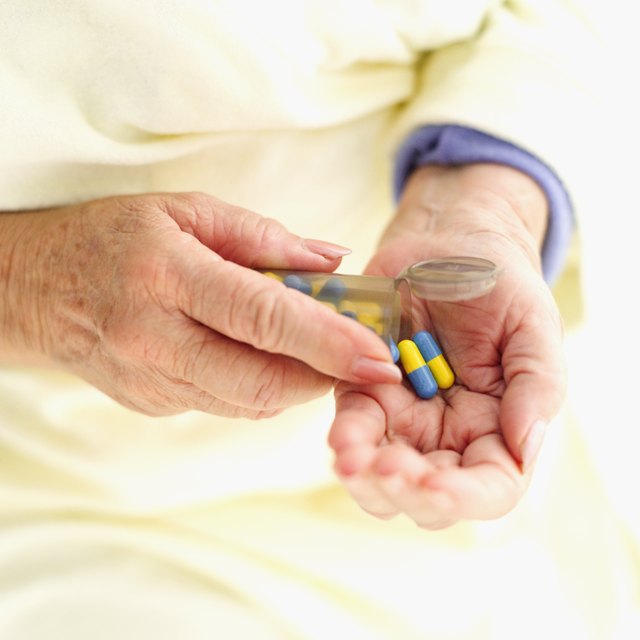 elderly woman taking medicine pills from container
